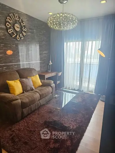 Cozy living room with plush sofa, stylish decor, and large window for natural light.
