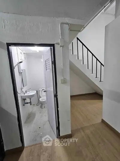 Compact bathroom under staircase in minimalist interior design