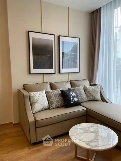 Elegant living room with chic decor and natural light, featuring a stylish sofa and marble coffee table.