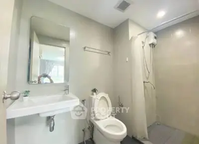 Modern bathroom with shower and toilet in a bright, minimalist design.
