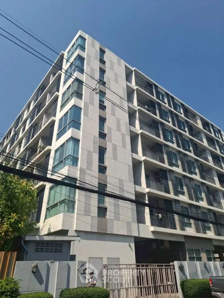 Modern architectural building with sleek design and spacious balconies.