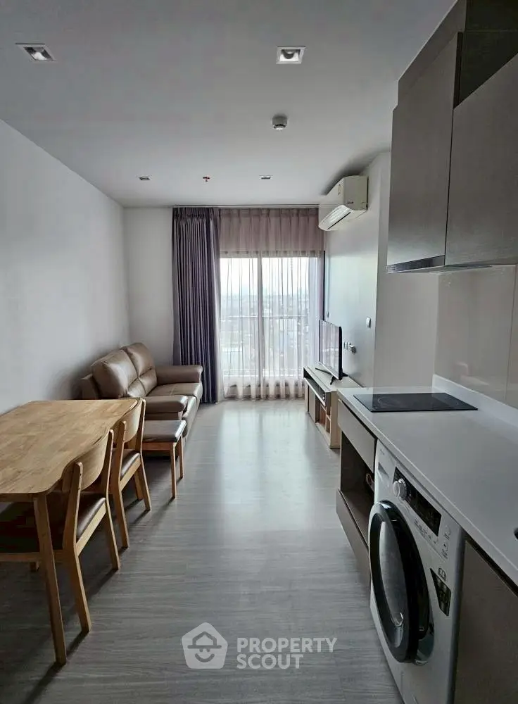 Modern living room with dining area and kitchen appliances in a bright apartment