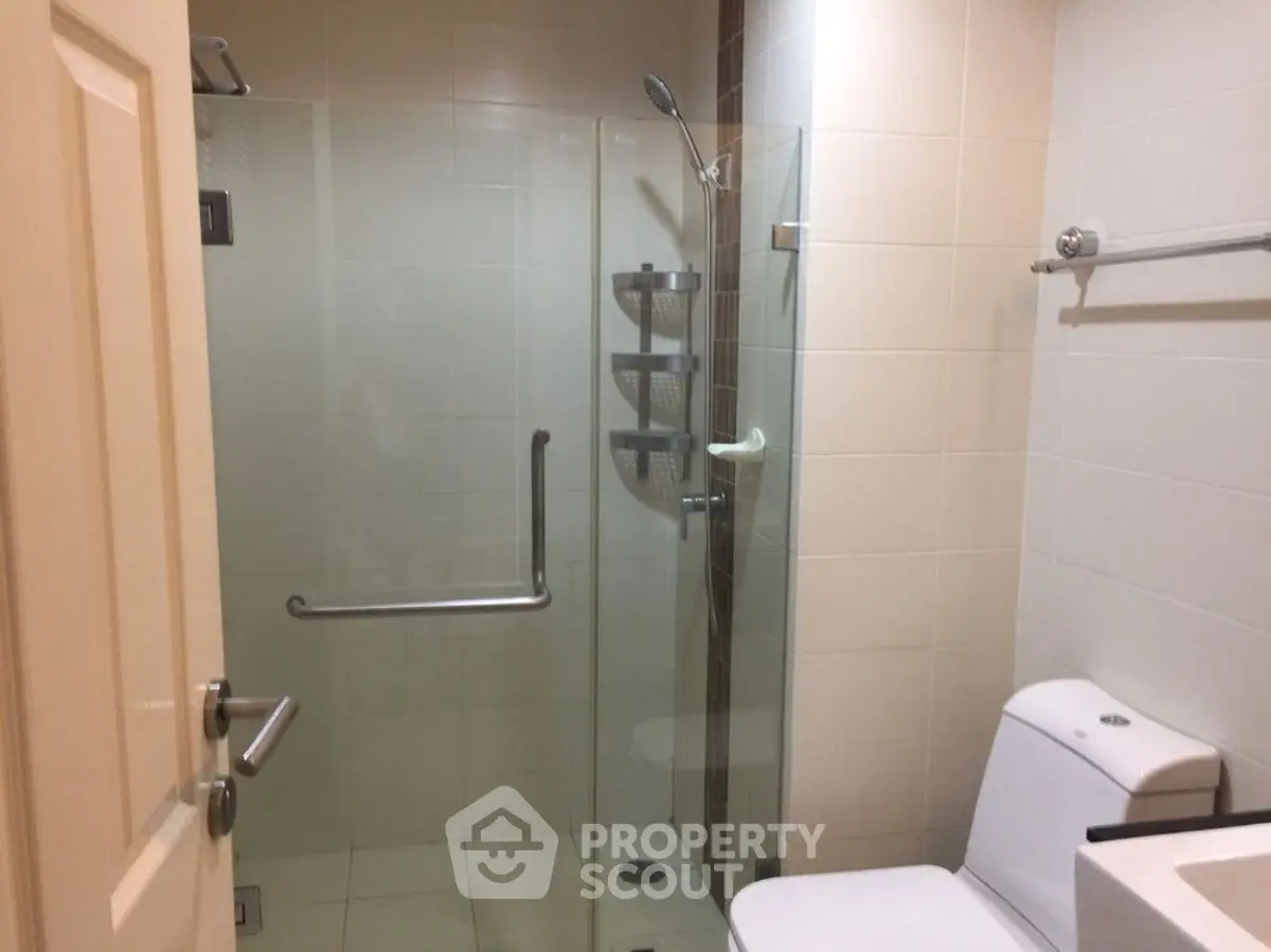 Modern bathroom with glass shower enclosure and sleek fixtures.