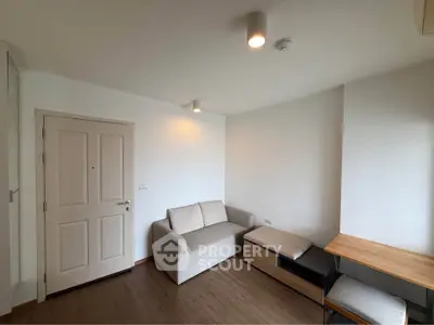 Cozy living room with modern furniture and wooden flooring in a minimalist apartment.