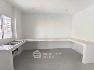 Spacious minimalist kitchen with ample counter space and natural light.