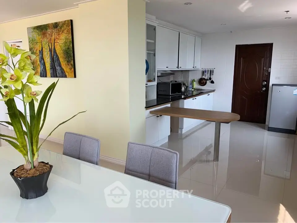 Modern open kitchen with sleek design and dining area, featuring stylish decor and natural light.