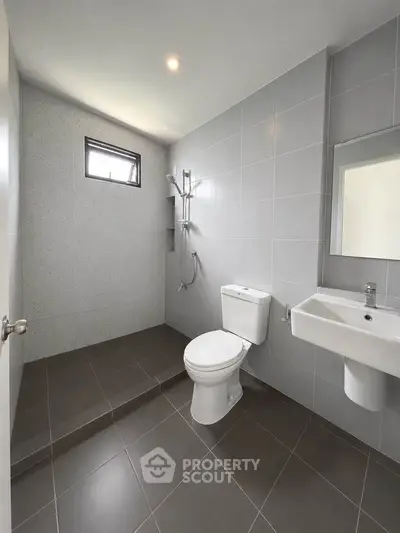 Modern minimalist bathroom with sleek gray tiles and walk-in shower