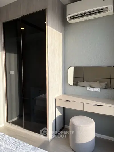 Modern bedroom with sleek wardrobe and stylish vanity under natural light.