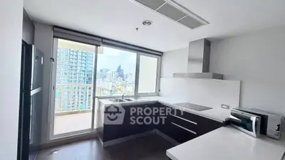 Modern kitchen with sleek design and city view from balcony, featuring built-in appliances and ample natural light.