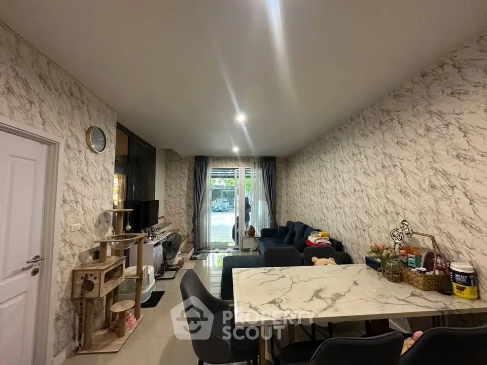 Stylish living room with marble accents and modern furniture, featuring a cozy seating area and dining space.