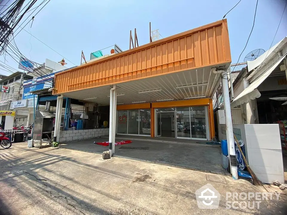 Commercial property with spacious parking area and modern facade in urban setting.