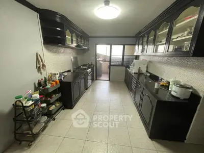 Spacious kitchen with ample counter space, modern appliances, and a bright, airy feel, leading to a sunlit balcony.