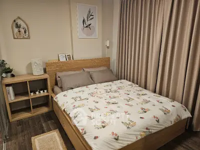 Cozy bedroom with floral bedding and wooden furniture, perfect for a relaxing retreat.