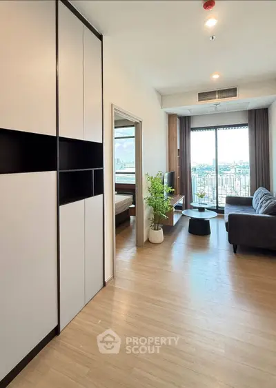 Modern living room with city view, featuring sleek furniture and natural light.