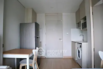 Modern kitchen with washing machine and fridge in compact apartment
