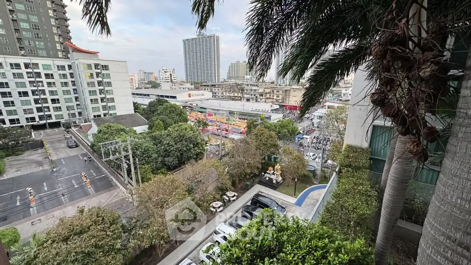 Stunning urban view from a high-rise balcony overlooking cityscape and lush greenery.