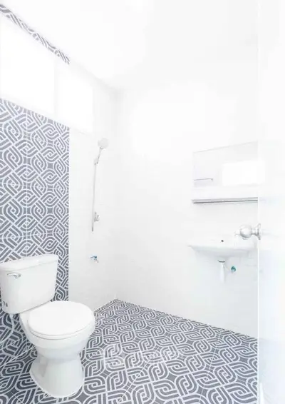 Modern bathroom with geometric tile flooring and minimalist fixtures.