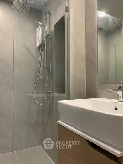 Modern bathroom with sleek shower and stylish sink in contemporary design.
