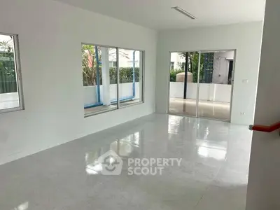 Spacious modern living room with large windows and glossy floors