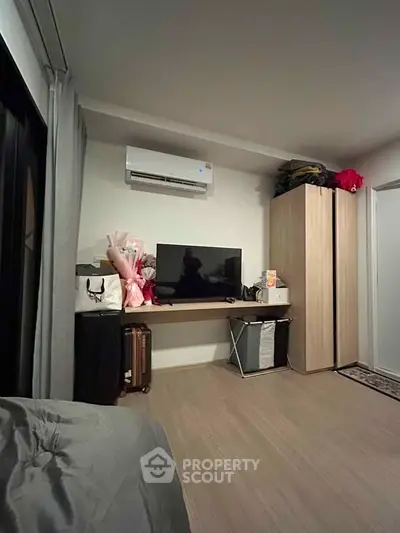 Cozy bedroom with modern air conditioning and sleek wooden flooring, perfect for comfortable living.