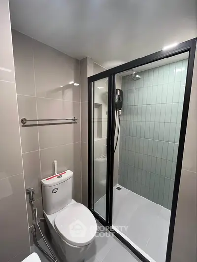 Modern bathroom with glass shower enclosure and sleek fixtures.