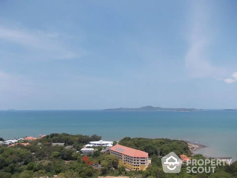 Stunning ocean view from a high vantage point overlooking a coastal property with lush greenery.