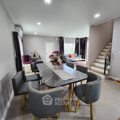 Modern dining area with elegant table and chairs, open layout to living room, stylish decor and natural light.