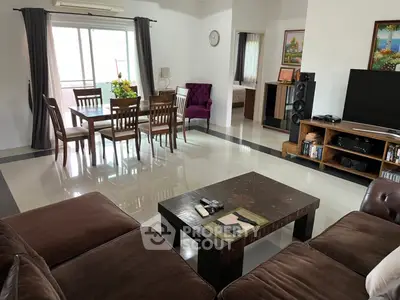Spacious living room with elegant dining area and modern entertainment setup