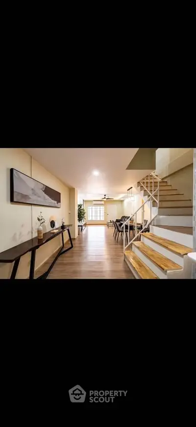 Spacious modern living room with elegant staircase and dining area