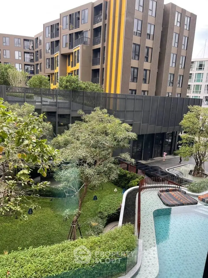 Modern apartment complex with lush garden and inviting pool area