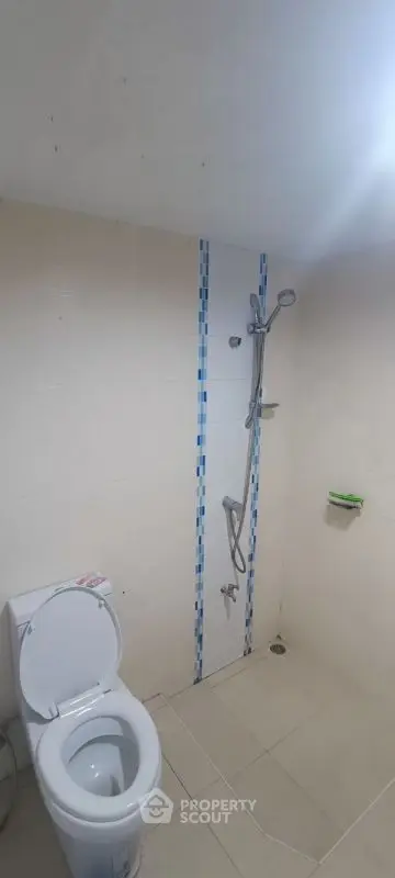 Compact bathroom with shower and toilet in minimalist design.