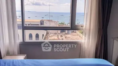 Stunning ocean view from a cozy bedroom window in a high-rise apartment.