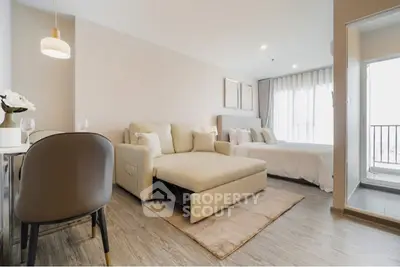 Modern studio apartment with open layout, featuring cozy living area and bedroom, complemented by a small balcony.