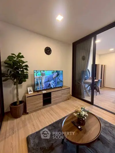 Modern living room with stylish decor and sliding glass doors leading to a balcony.