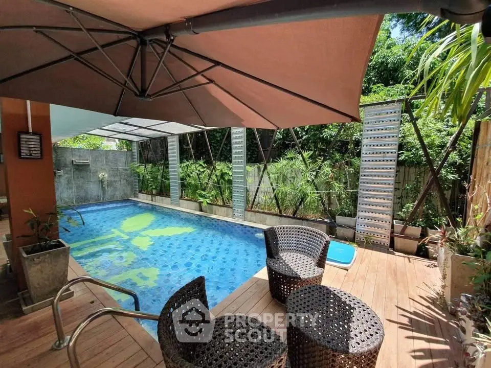Luxurious private pool area with stylish seating and lush greenery, perfect for relaxation and entertainment.