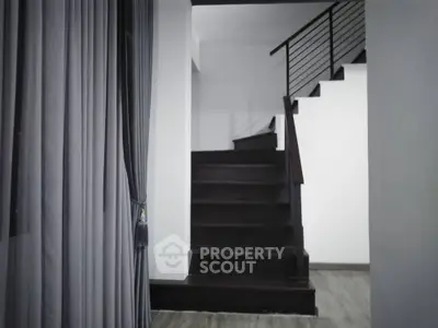 Modern interior staircase with sleek railing and elegant curtains
