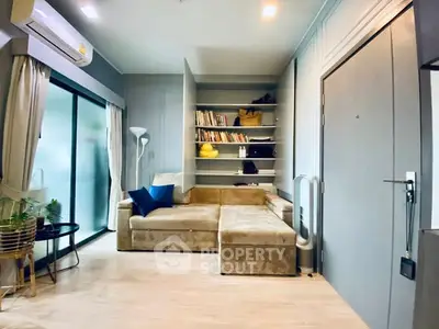 Modern living room with cozy beige sofa, built-in shelves, and sliding glass doors to balcony.