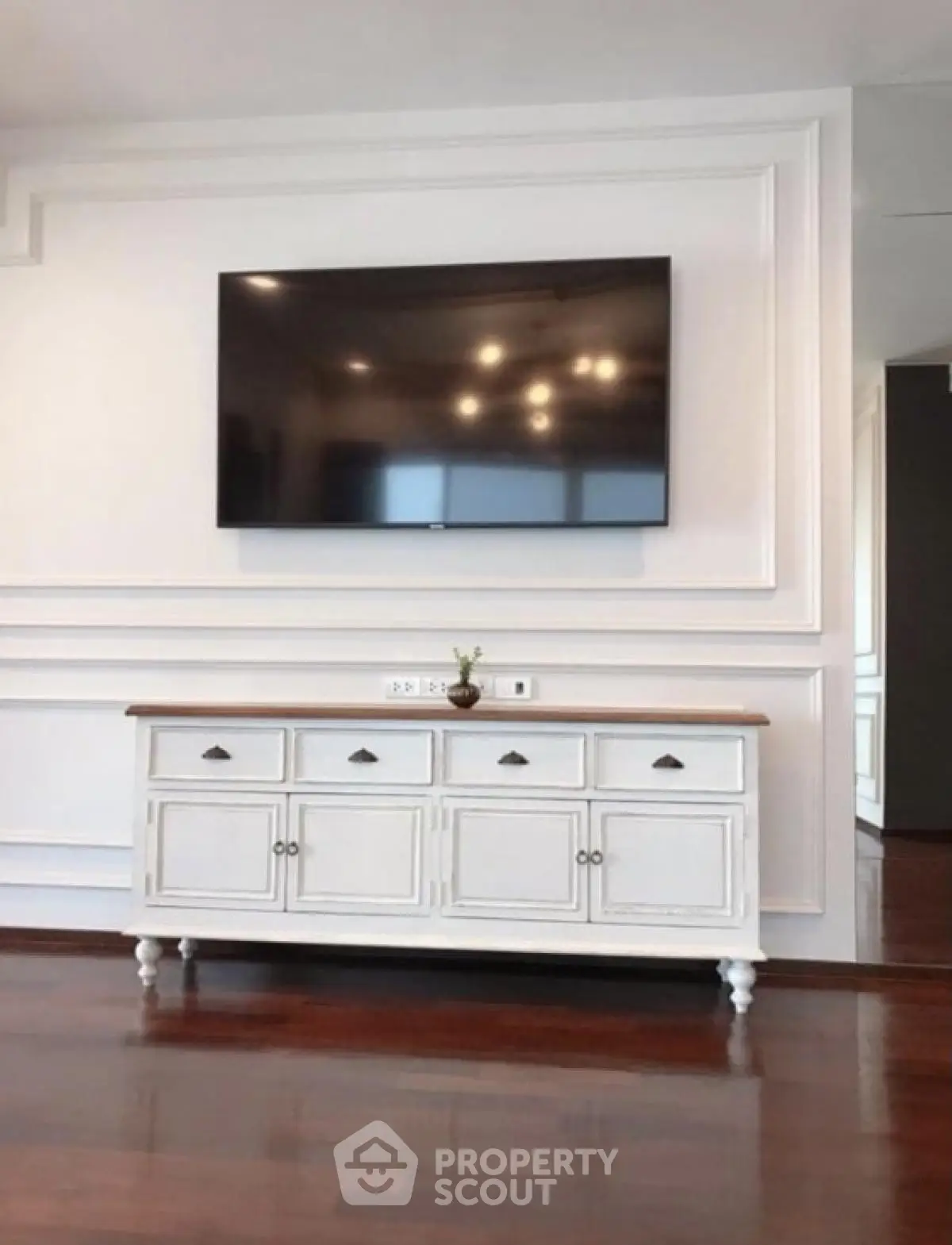 Elegant living room with mounted TV and stylish white console table.