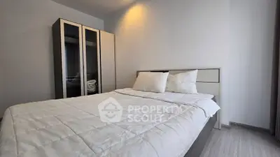 Modern bedroom with sleek wardrobe and cozy bedding in a minimalist design.