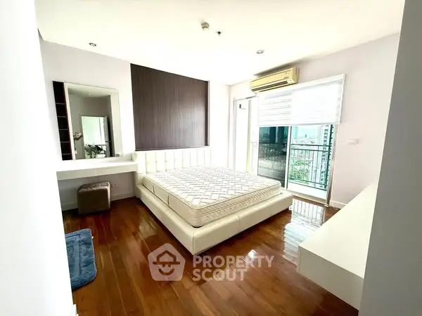 Spacious bedroom with modern design and balcony access in a luxury apartment.