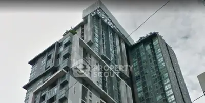 Modern high-rise building with sleek architectural design and large windows in urban setting.