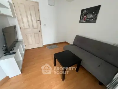 Cozy living room with modern decor, featuring a sleek sofa, flat-screen TV, and stylish wall art.