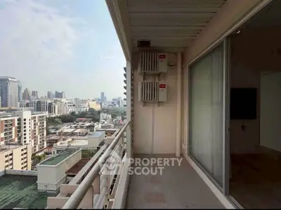 Spacious balcony with stunning cityscape view in modern high-rise building.