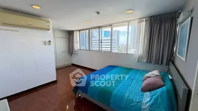 Spacious bedroom with city view and air conditioning in modern apartment.