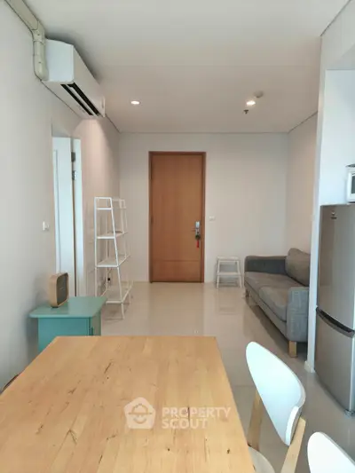 Modern apartment interior with sleek furniture and open layout, featuring a cozy living area and dining space.