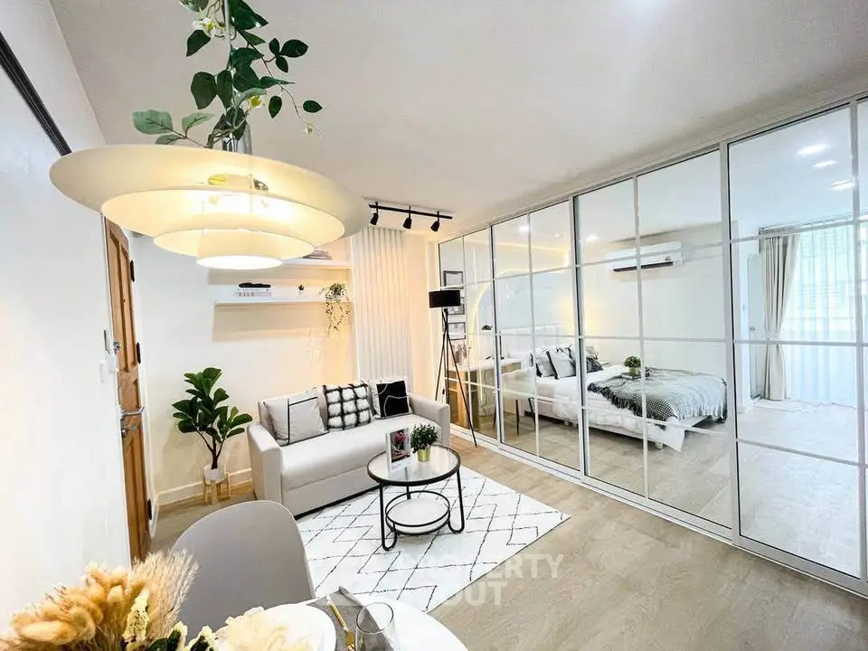 Modern open-concept living room with stylish decor and mirrored wardrobe