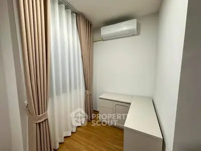 Cozy small room with elegant curtains and air conditioning, perfect for a study or storage space.
