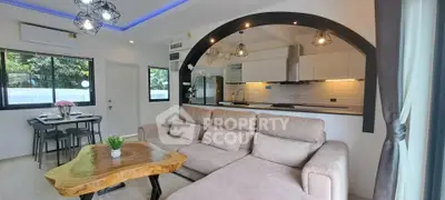 Modern open-layout living room with stylish kitchen and cozy seating area.