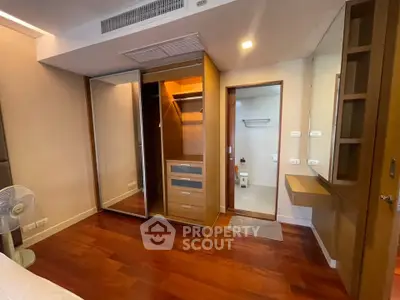 Spacious bedroom with walk-in closet and elegant wooden flooring