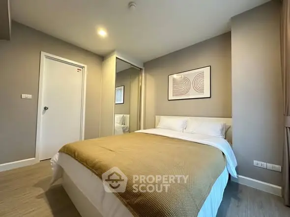 Modern bedroom with cozy decor and neutral tones, featuring a comfortable bed and stylish artwork.